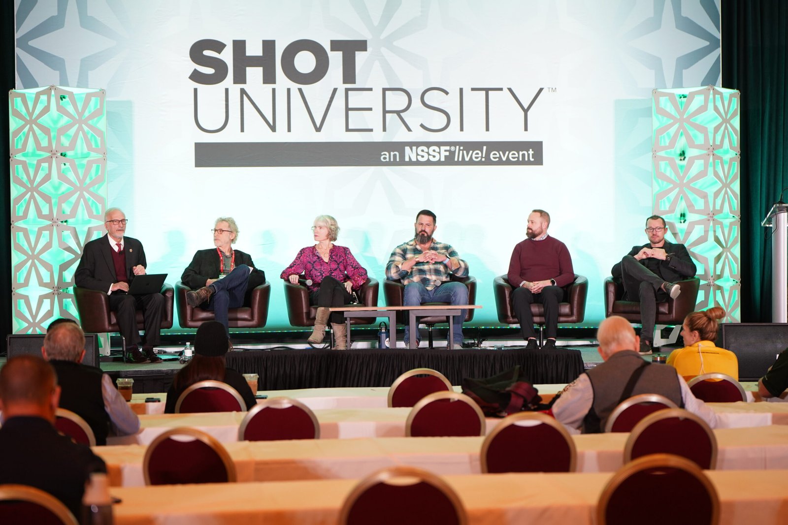 Painel da Shot University debate prevenção ao suicídio diante de auditório.