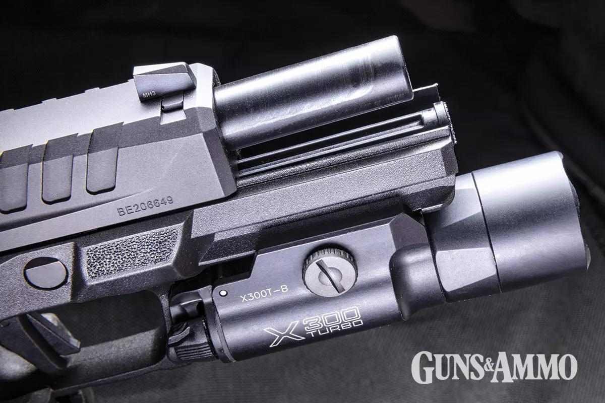 Pistola Echelon equipada com lanterna e ferrolho parcialmente aberto.