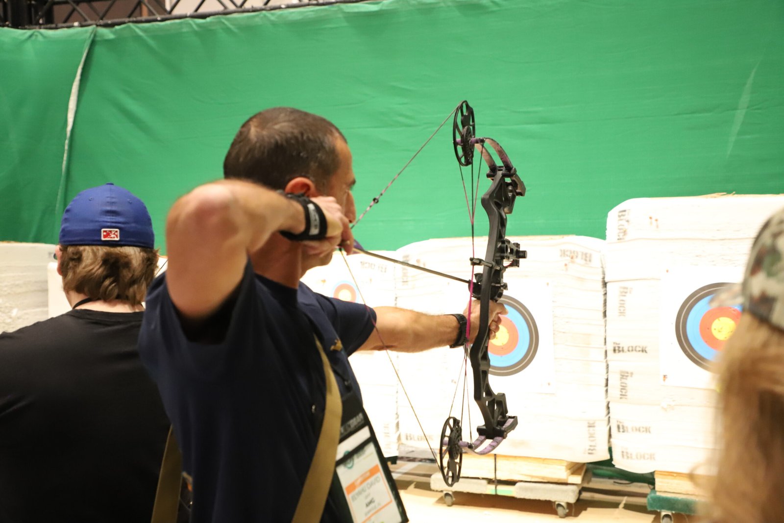 Visitante testa arco composto em área de demonstração da Shot Show.