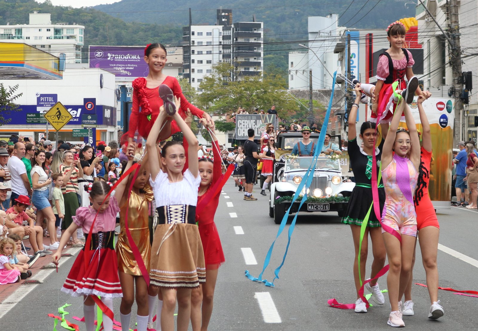 Jovens artistas se apresentam com fitas coloridas no desfile da Schützenfest.