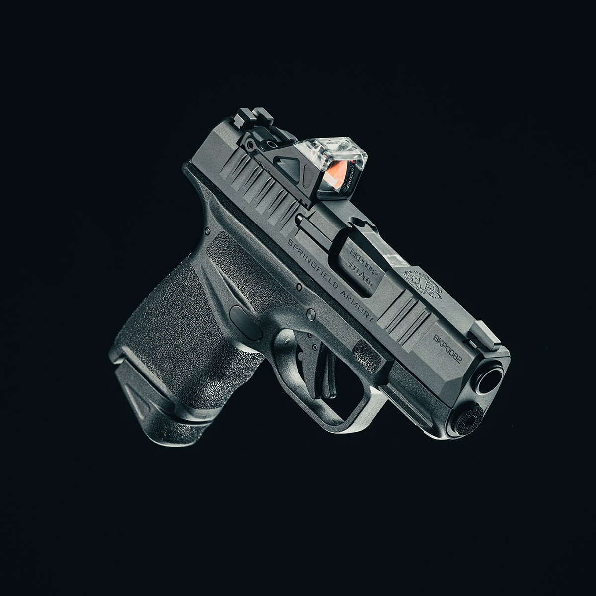 Pistola Springfield Armory Hellcat .380 ACP vista em perspectiva sobre fundo preto.