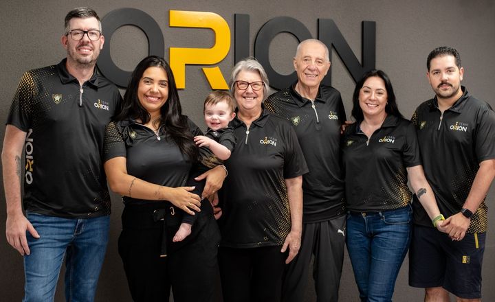 Equipe do Clube de Tiro Orion posa reunida, incluindo uma criança.