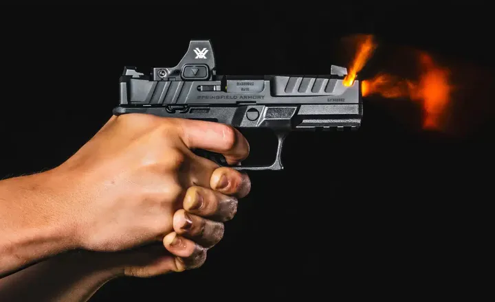 Pistola Springfield Armory Echelon dispara contra fundo preto.
