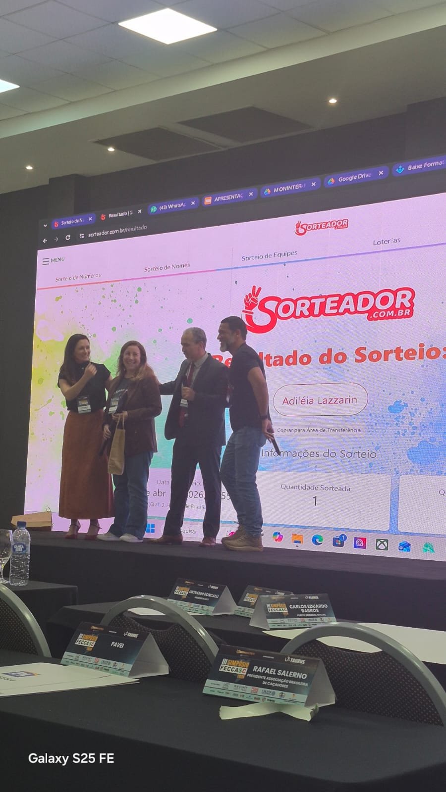 Organizadores acompanham sorteio projetado em tela durante o Simpósio FECCASC.