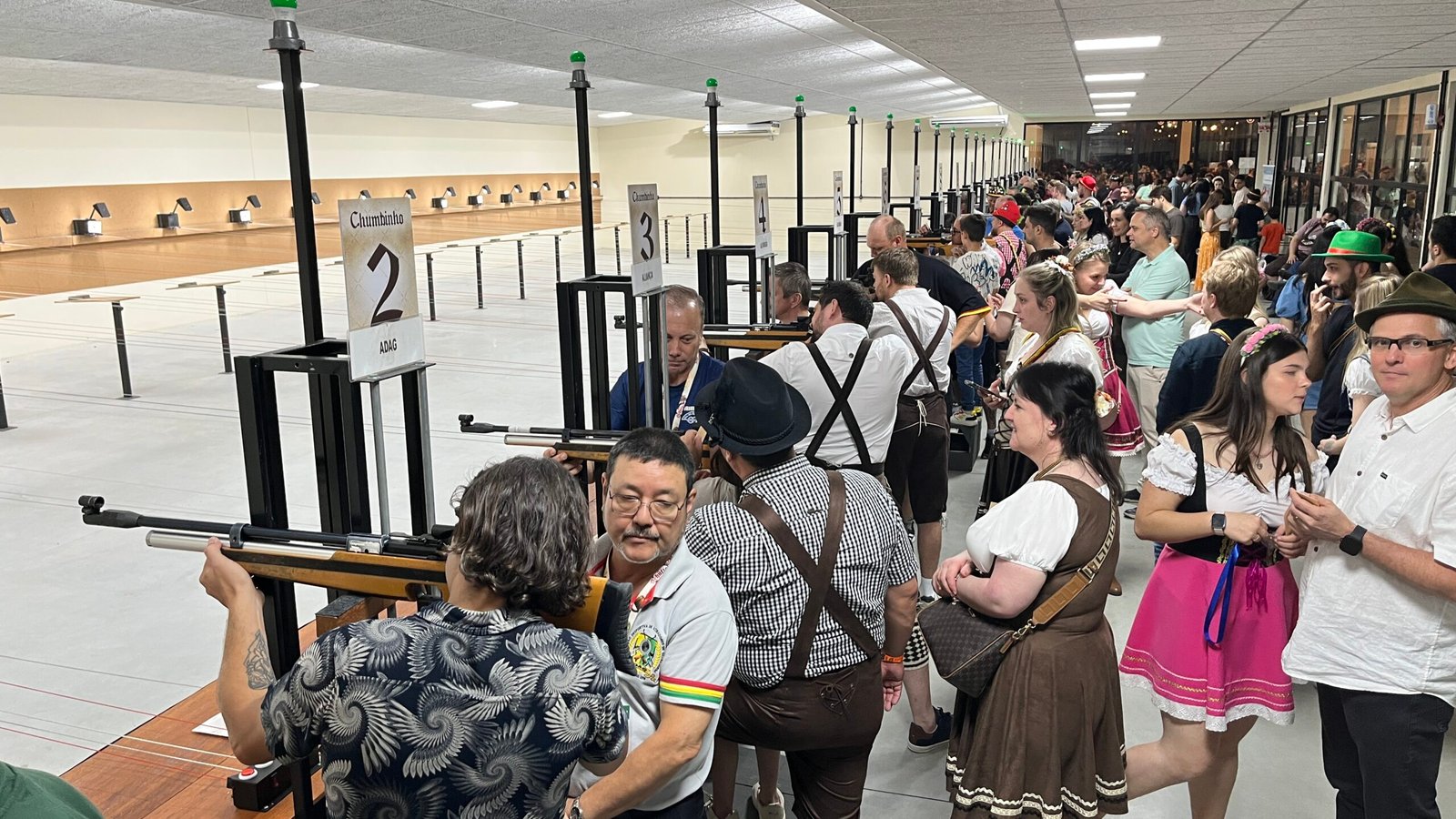 Público acompanha atividades de tiro esportivo em estande coberto durante a Schützenfest.