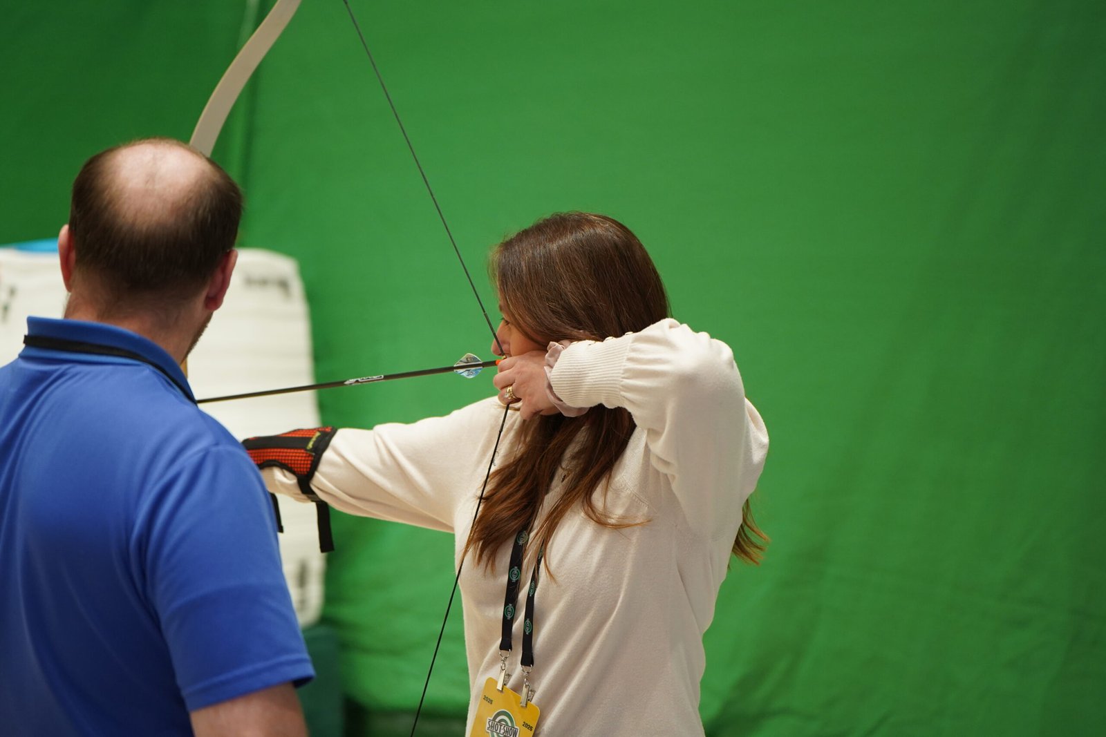 Visitante pratica arco e flecha em área de demonstração da Shot Show.