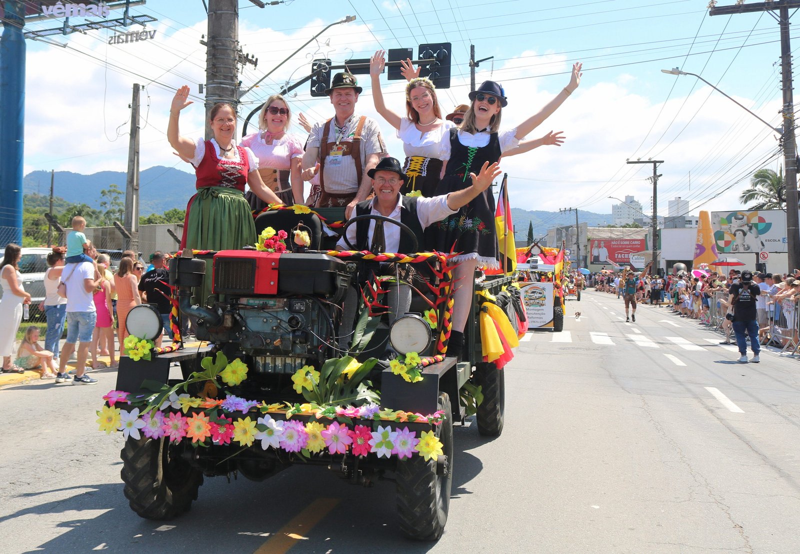 Participantes em trajes alemães desfilam sobre carro alegórico na Schützenfest.