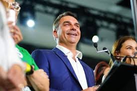 Jair Bolsonaro sorri entre apoiadores durante evento público.