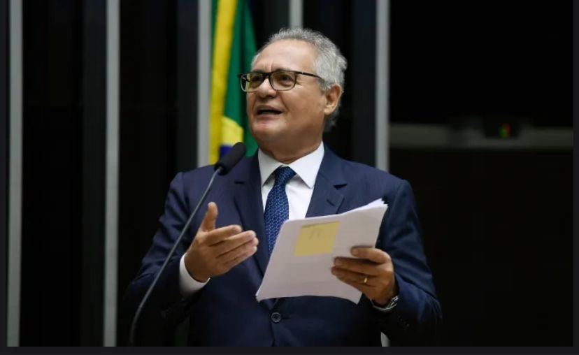 Senador discursa no plenário segurando documentos.
