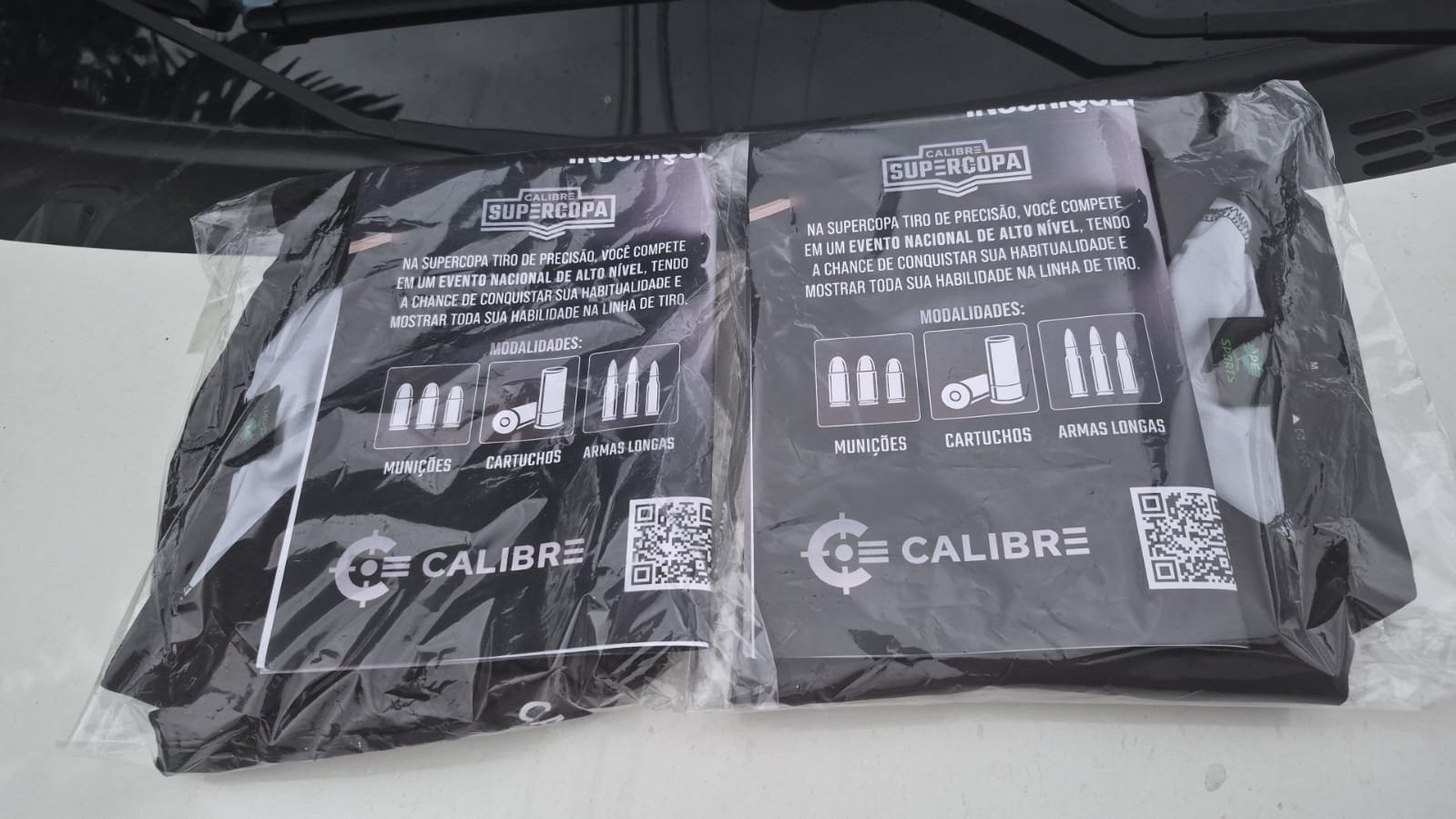 Duas camisetas da Calibre Supercopa embaladas sobre uma mesa.