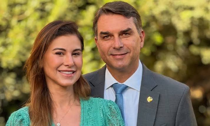 Jair Bolsonaro posa ao lado de uma mulher em área externa.