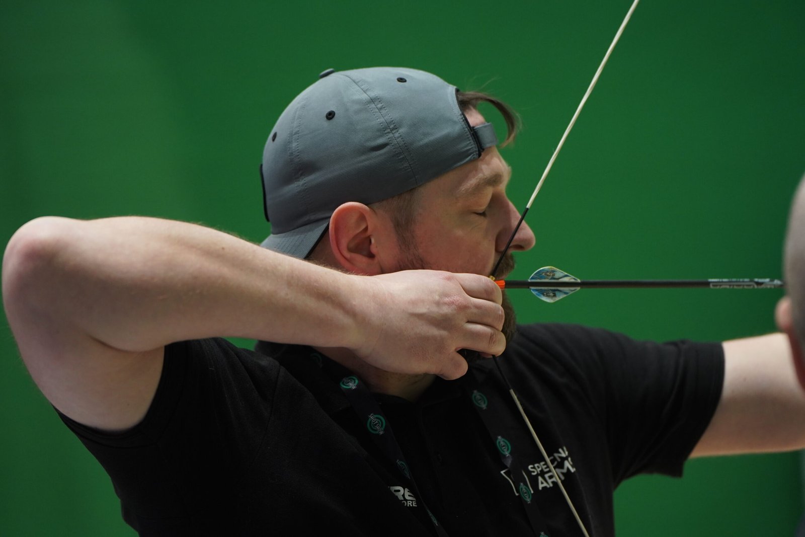 Visitante pratica arco e flecha em área de demonstração da Shot Show.