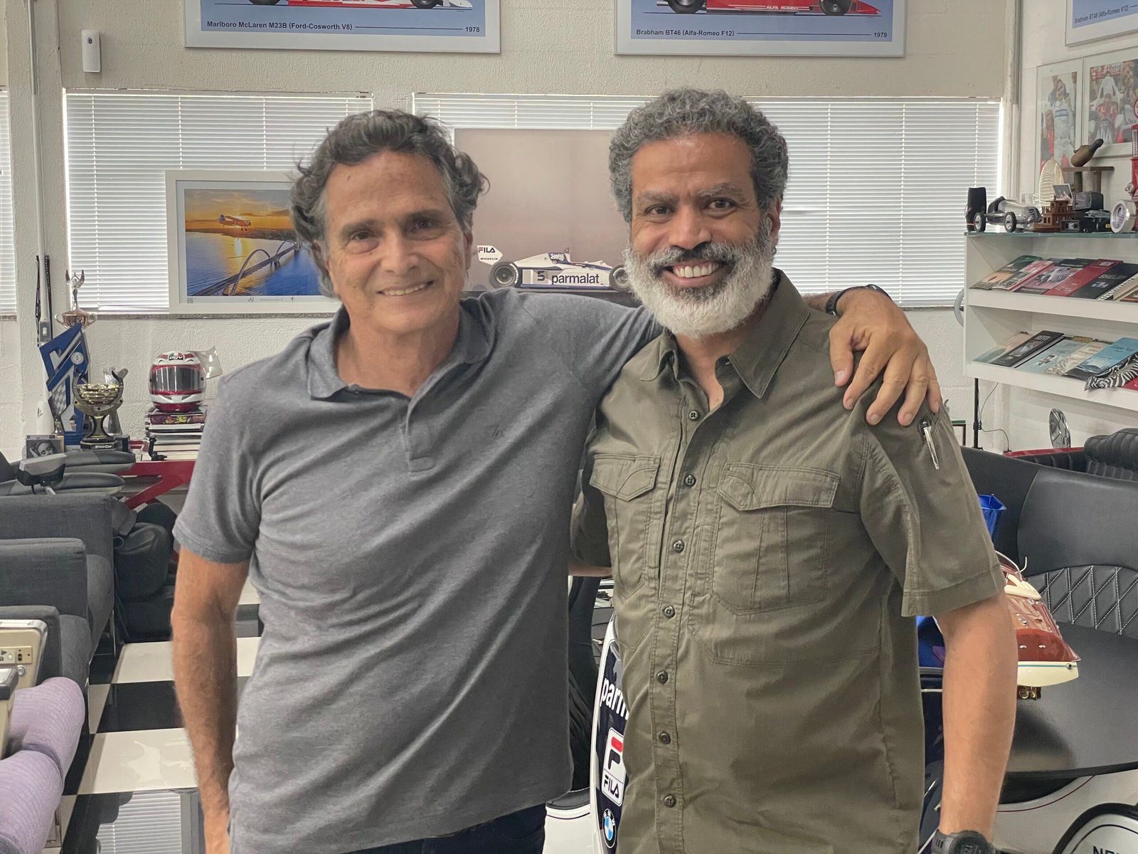 Demetrius Oliveira posa com colega em escritório decorado com itens do tiro.