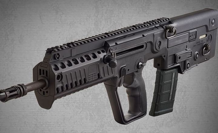 Fuzil bullpup IWI Tavor X95 visto de perfil sobre fundo cinza.