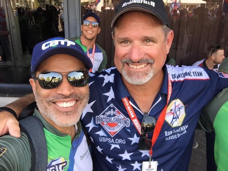 Demetrius Oliveira posa com atleta americano de tiro prático.