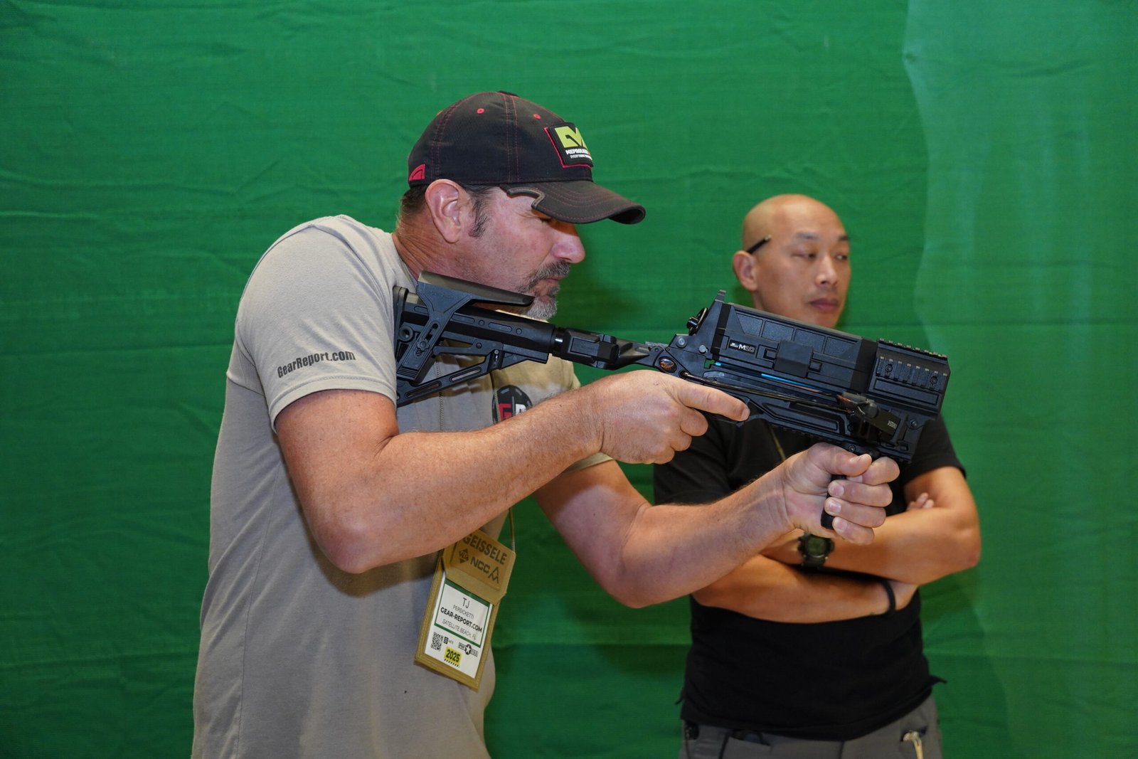 Visitante demonstra arma longa em área de treinamento da Shot Show.