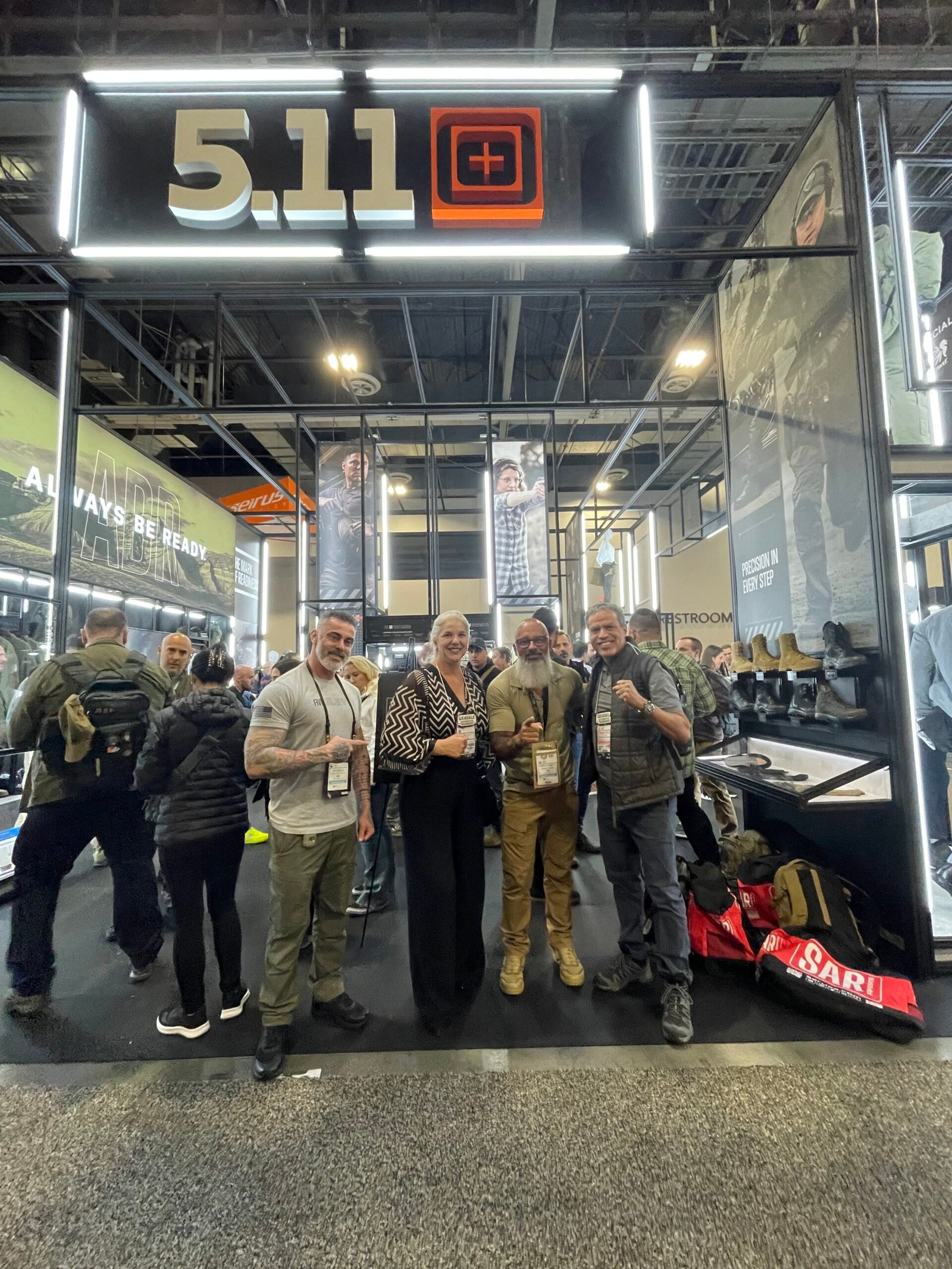 Grupo posa diante do estande da marca 5.11 Tactical.
