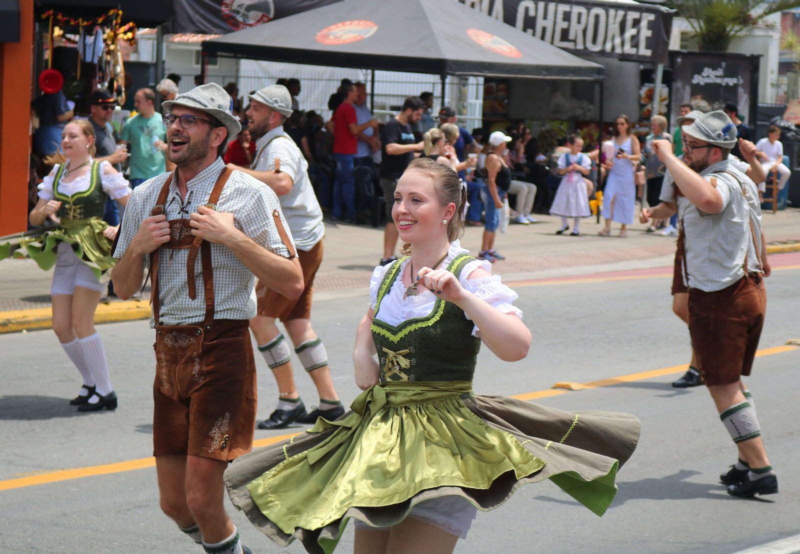 Casal em traje típico alemão dança em avenida durante a Schützenfest.