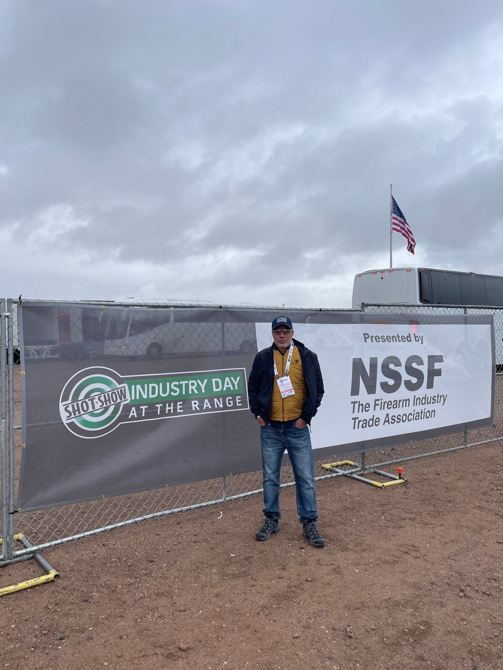 Participante posa diante da entrada do Industry Day at the Range.