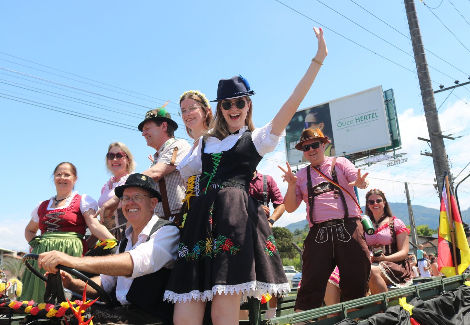 Participantes em trajes alemães desfilam sobre carro alegórico na Schützenfest.