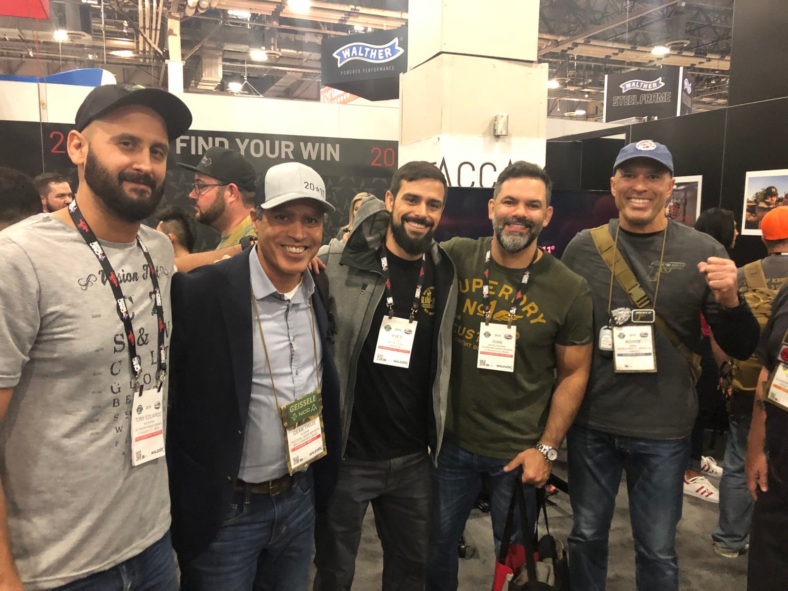 Demetrius Oliveira posa com atletas durante feira internacional.