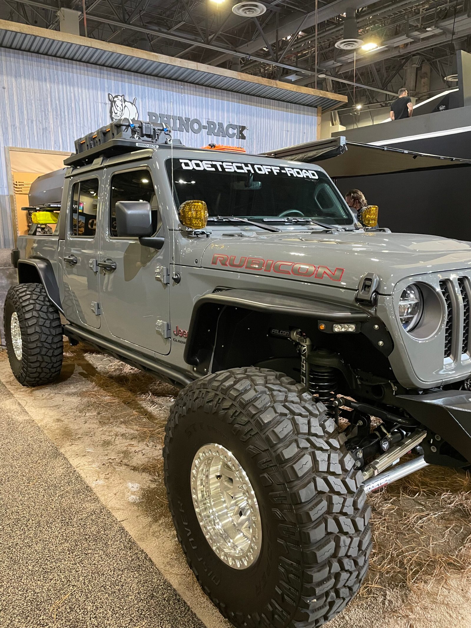 Veículo off-road cinza equipado para exposição em feira.