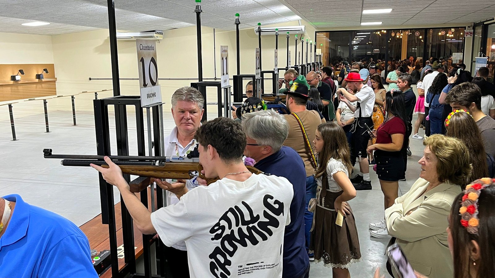 Público acompanha atividades de tiro esportivo em estande coberto durante a Schützenfest.