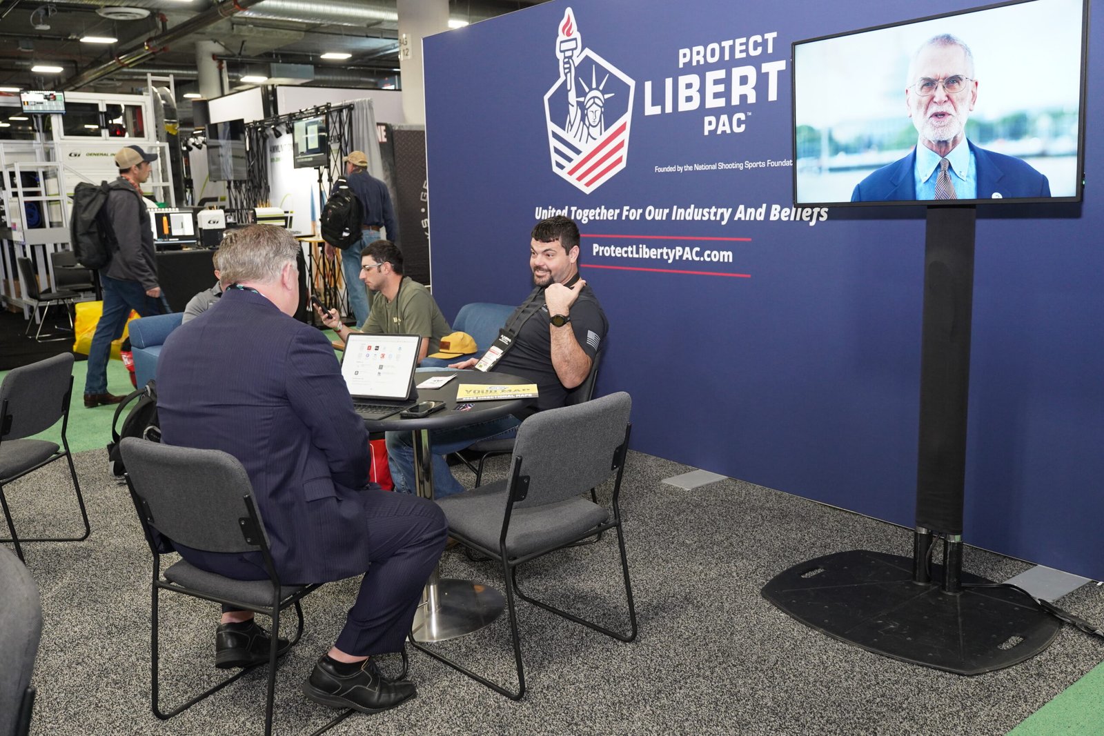 Representantes conversam em estande da Protect Liberty durante a Shot Show.