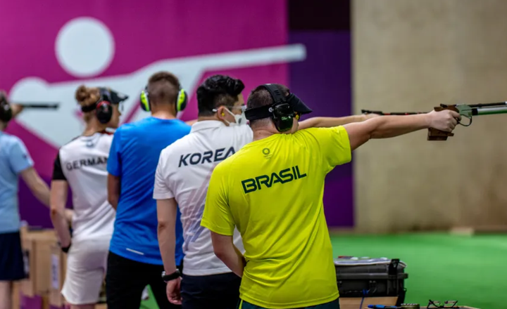Atleta brasileiro compete com pistola em uma prova internacional de tiro esportivo.