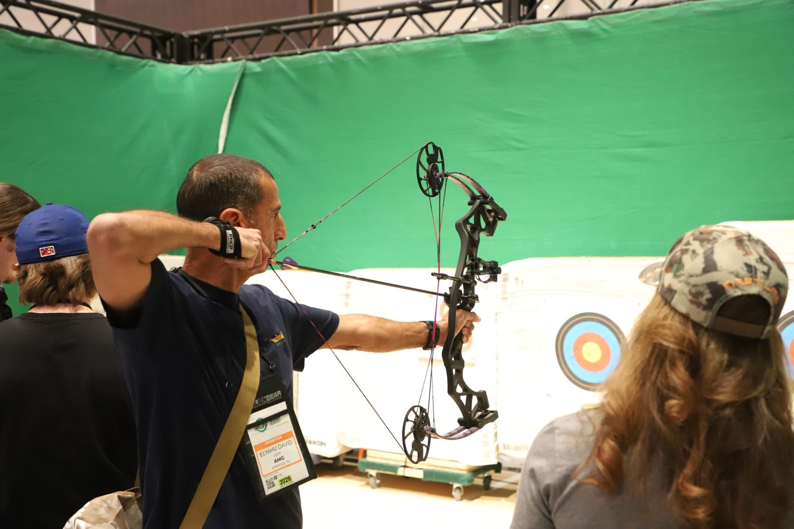 Visitante testa arco composto em área de demonstração da Shot Show.