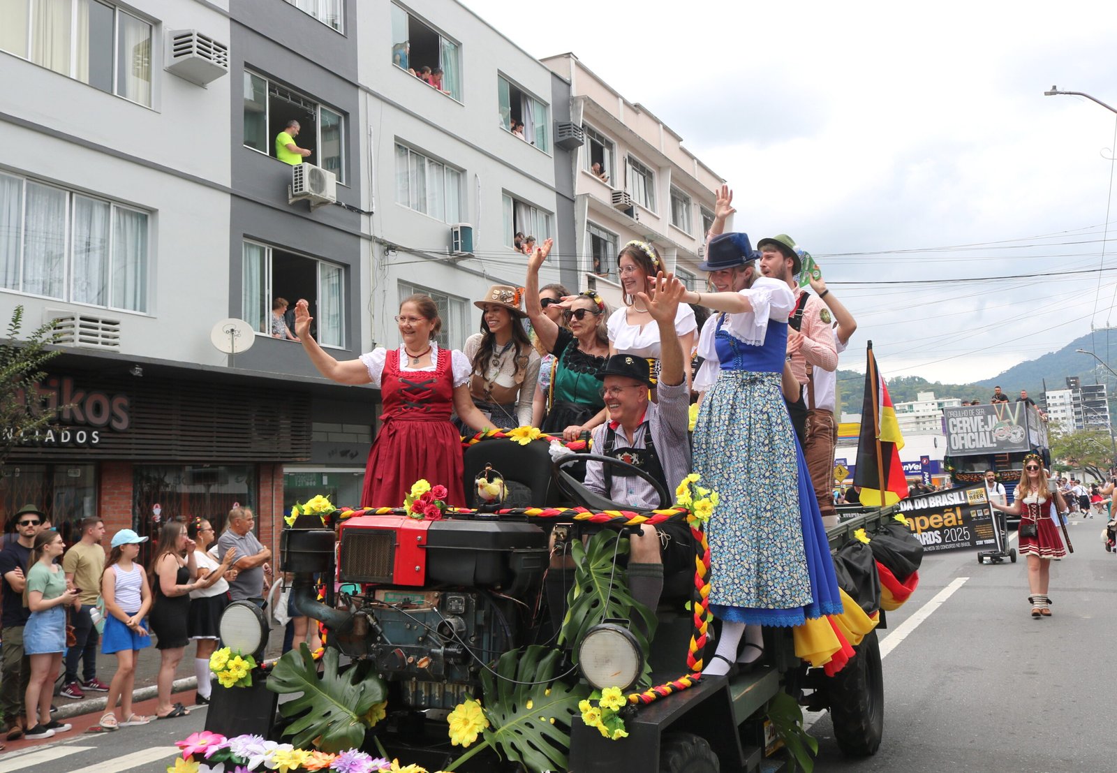 Participantes em trajes alemães desfilam sobre carro alegórico na Schützenfest.