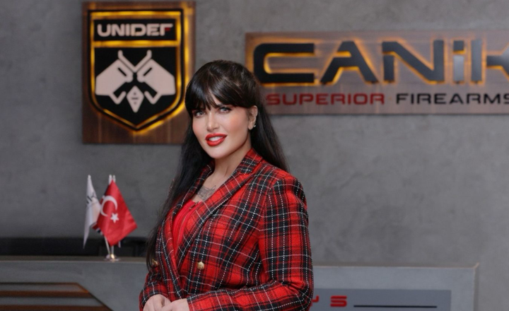 Mulher posa diante dos logotipos da Canik e da Unidef na Turquia.