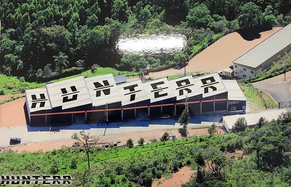 Vista aérea das instalações da Hunterr em área cercada por vegetação.