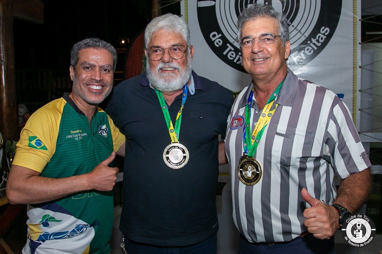 Demetrius Oliveira posa entre dois medalhistas do tiro esportivo.