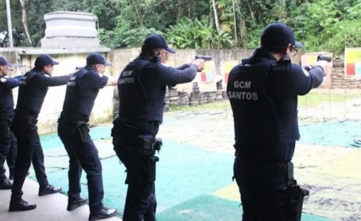 Guardas municipais de Santos praticam tiro em um estande ao ar livre.