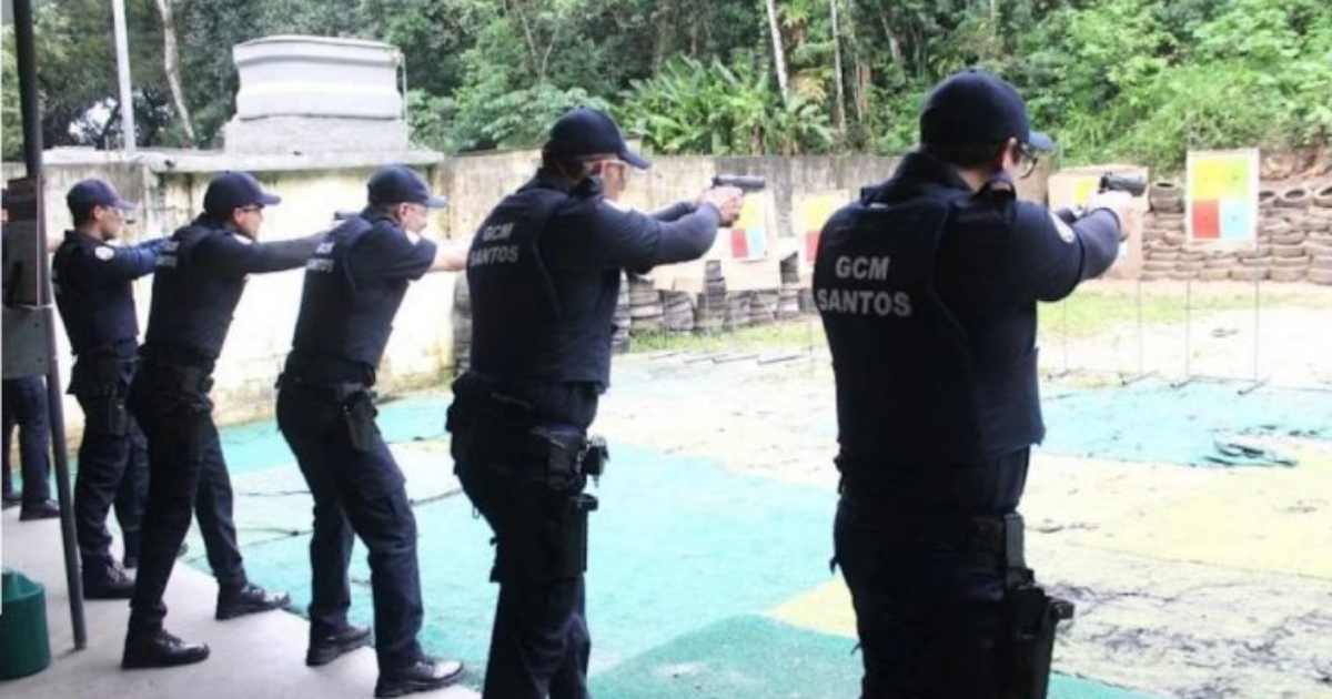 Guardas municipais de Santos praticam tiro em um estande ao ar livre.