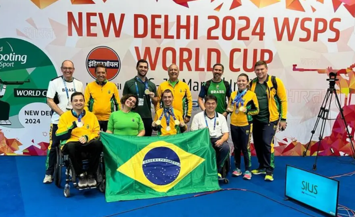 Delegação brasileira exibe medalhas e a bandeira nacional na Copa do Mundo de tiro.