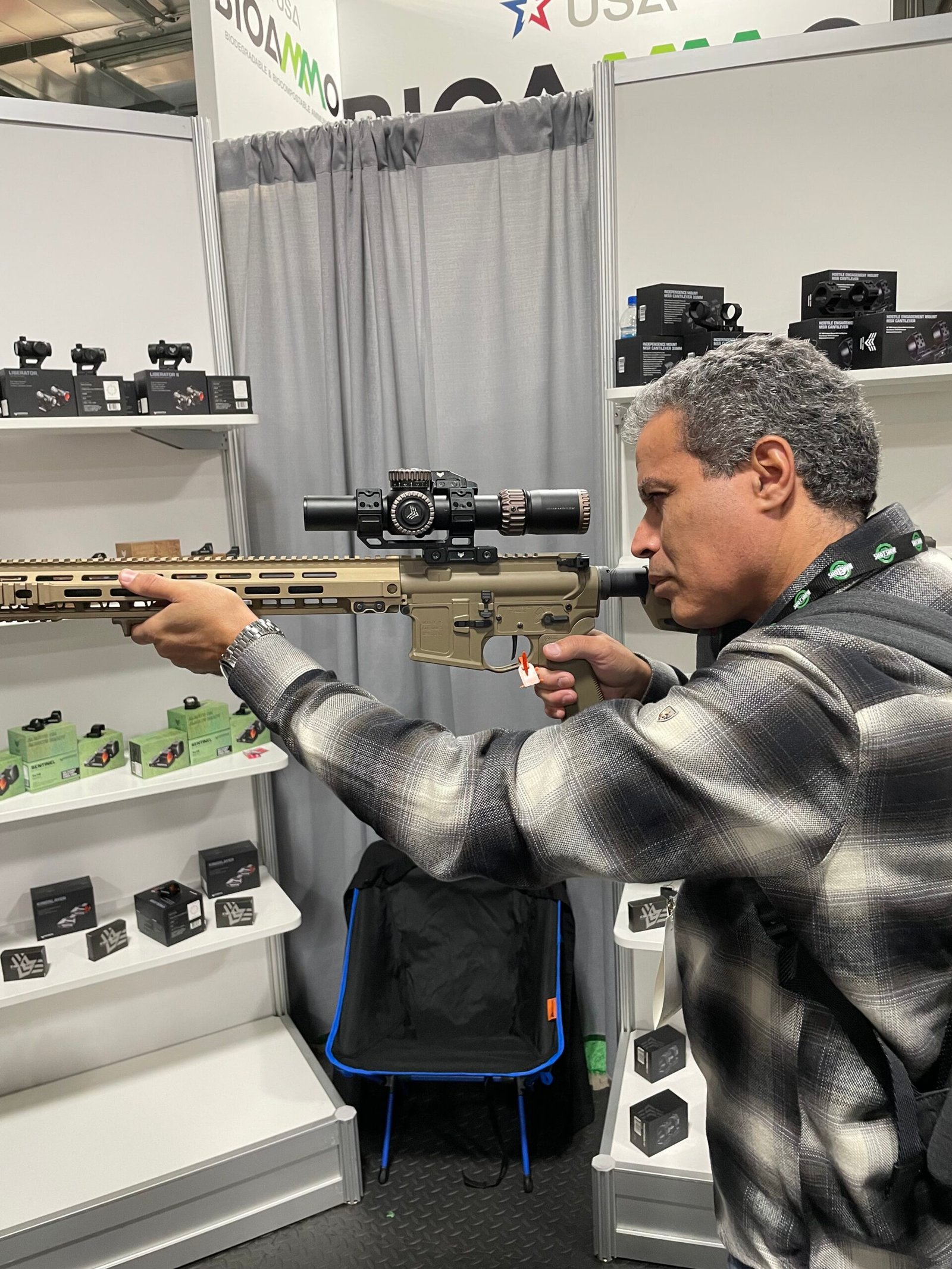 Demetrius Oliveira testa arma longa equipada com mira em estande.